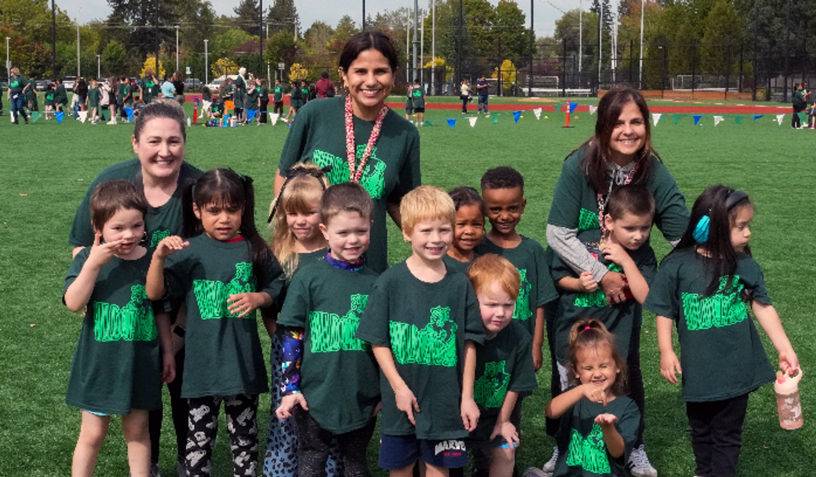 Pre-K students and teachers in their Wildcats shirts on the field